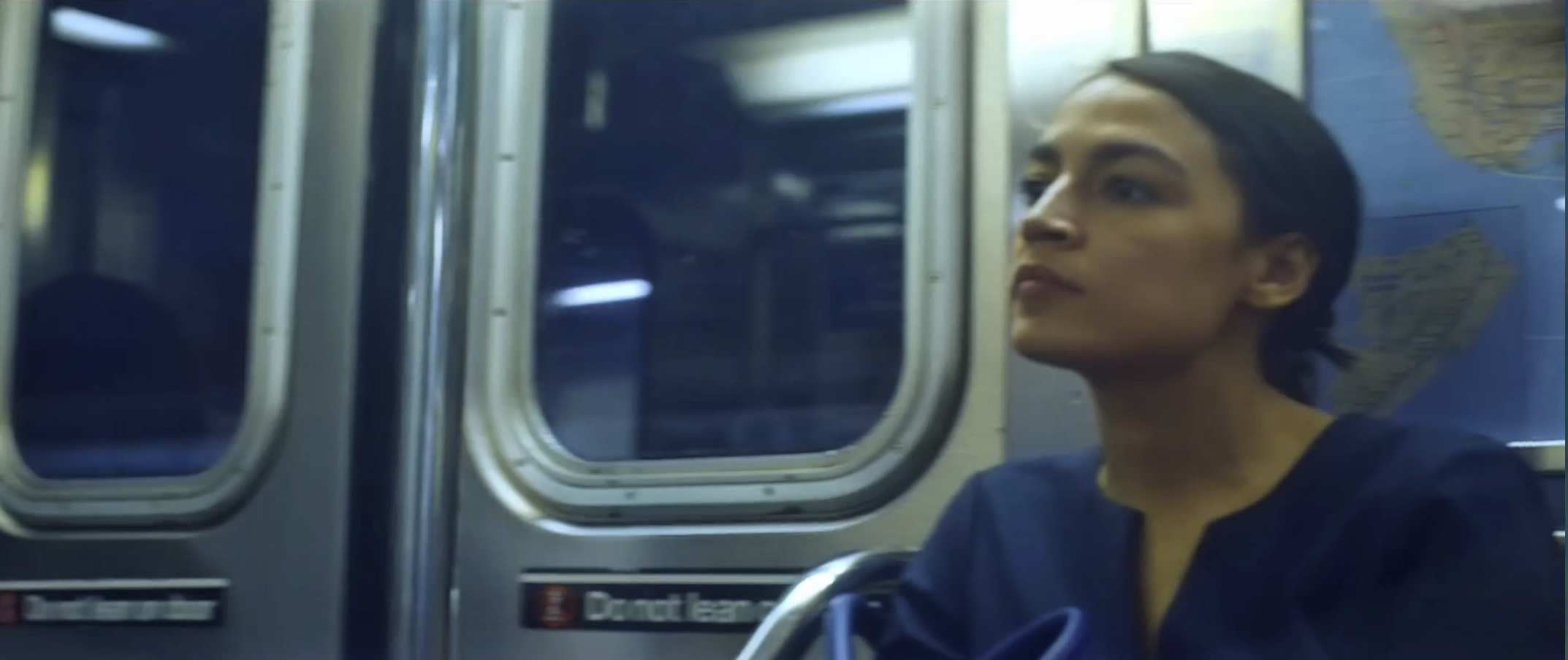 Alexandria Ocasio-Cortez seated on a subway train